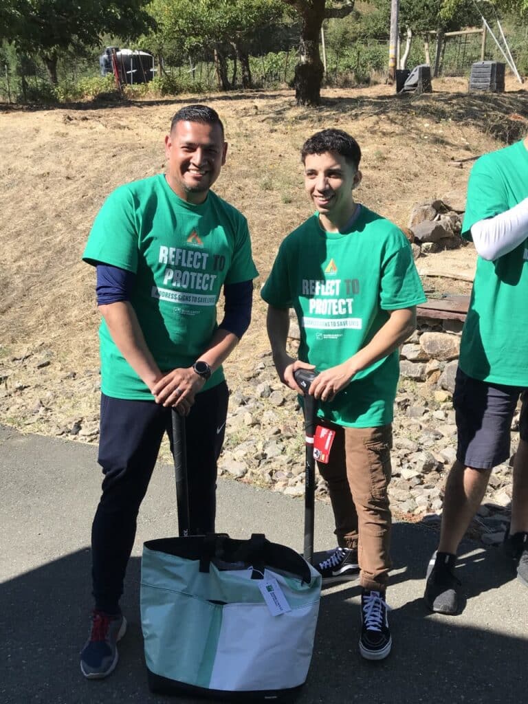 two volunteers holding equipment to put up signs 