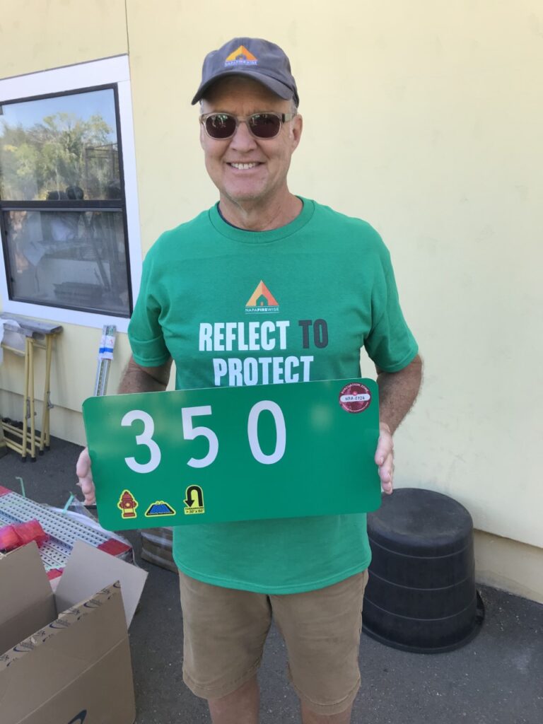 Volunteer holding green reflective sign 