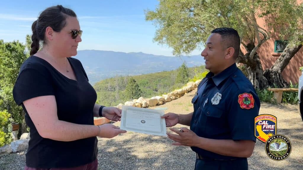 Homeowner Matilda Scott receives a Napa County Defensible Space Certificate from Napa County Fire Marshal Code Compliance Officer Erick Hernandez.
